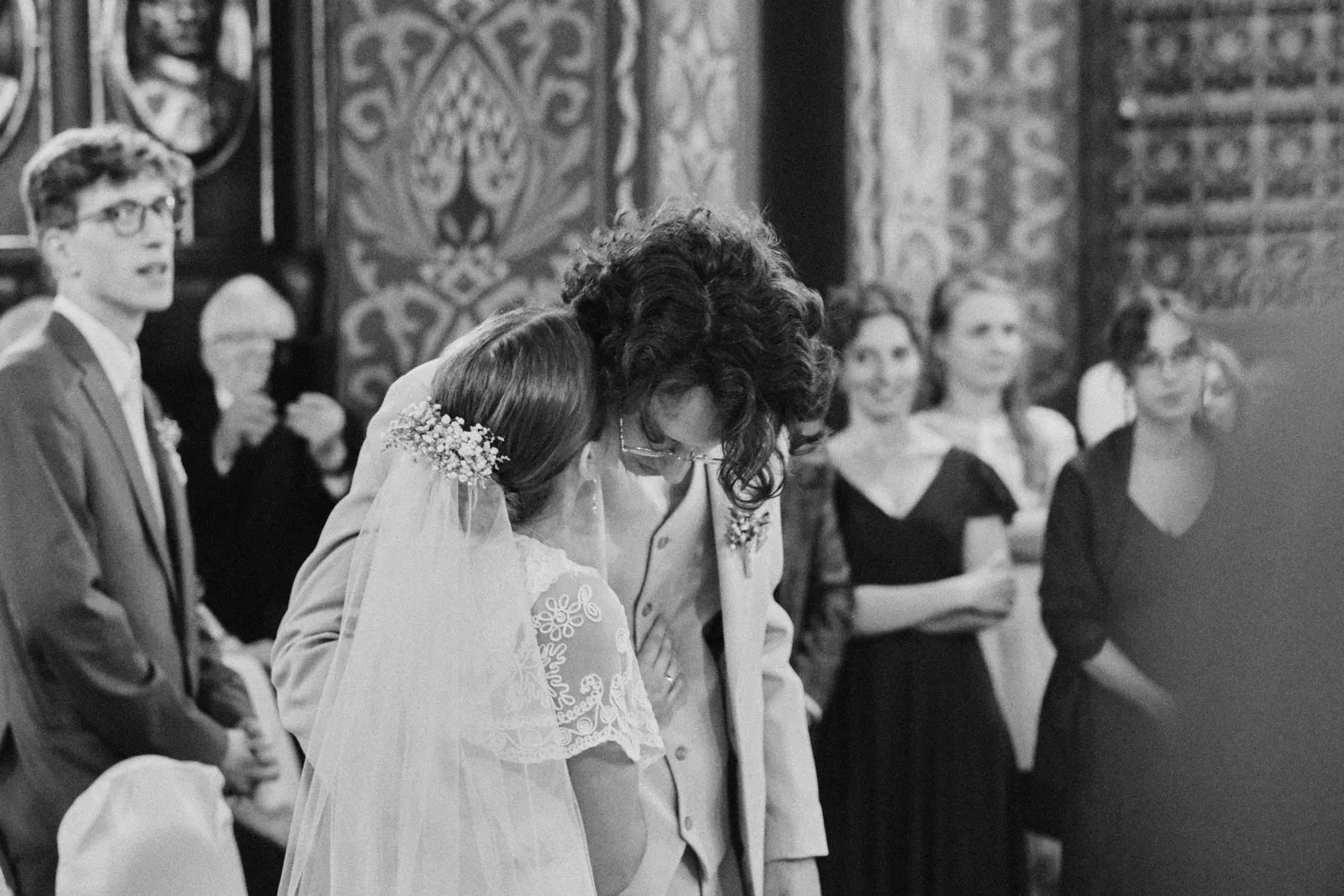 Emocjonalny moment podczas ceremonii ślubnej w kościele, para młoda w czułych objęciach.