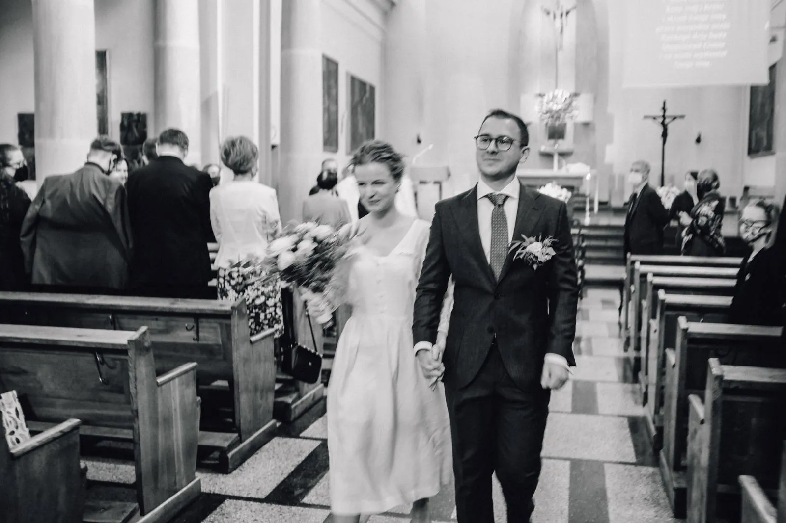 Para młoda wychodząca z kościoła po ceremonii ślubnej w Poznaniu.