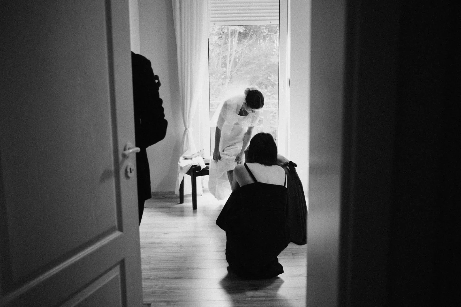 Panna młoda podczas przygotowań do ślubu, zakładanie welonu przez pomocnice.