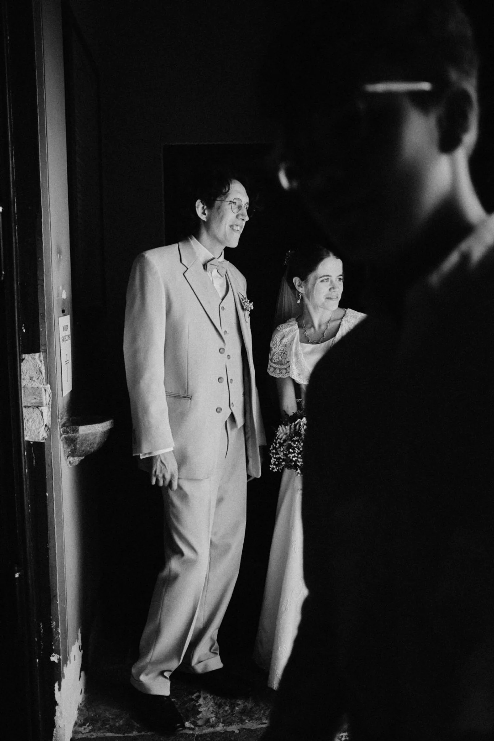 Para młoda stojąca w drzwiach wyjścia z kościoła po ceremonii ślubnej.