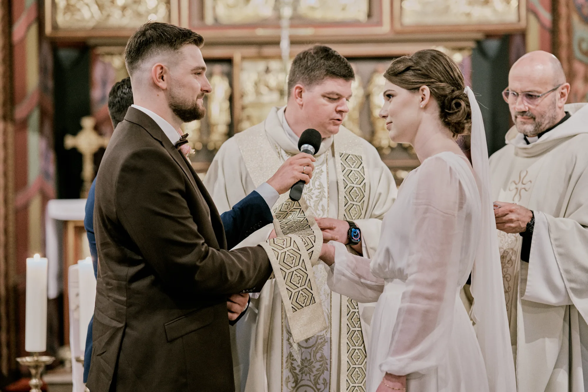 Ceremonia ślubna przy ołtarzu w zabytkowym kościele.