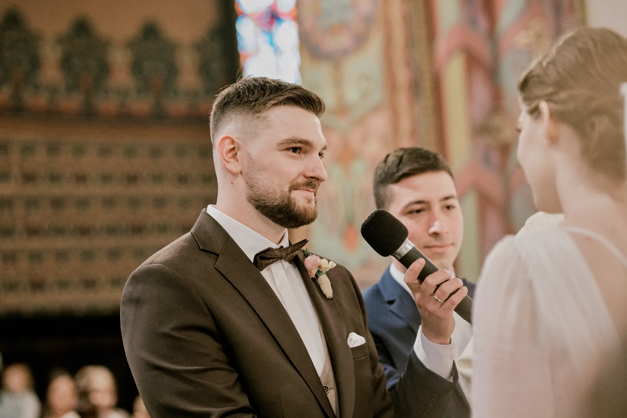 Świadek z mikrofonem podczas ceremonii ślubnej w kościele.